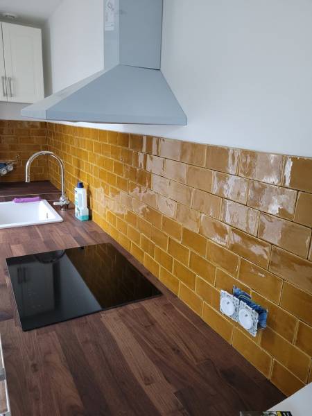 Pose petit carrelage mural cuisine sur plan de travail en bois dans un appartement à Cuges les pins